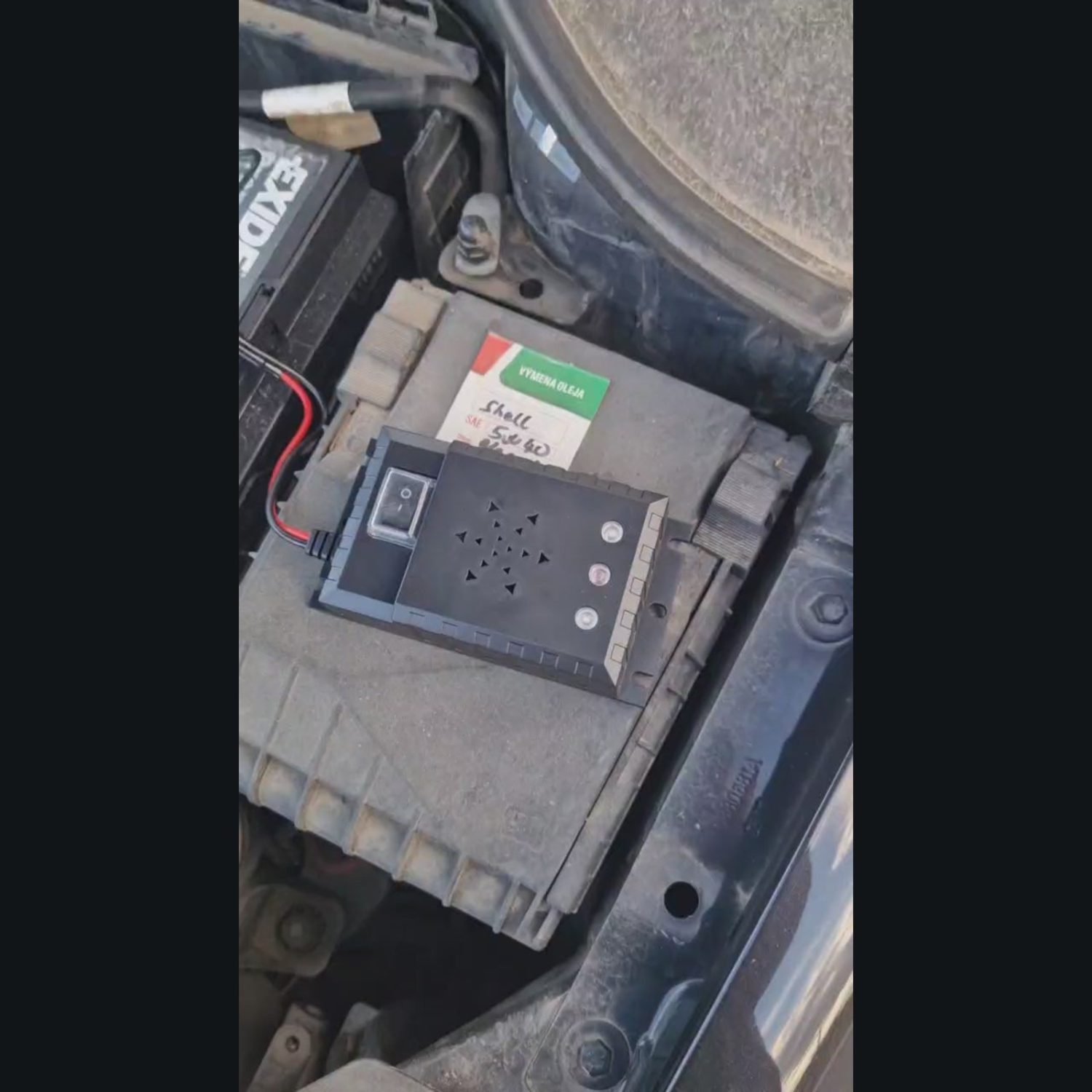 SHØK PRO 12V – ukážka funkcie (náhľad videa) Video: SHØK PRO 12V v motorovom priestore vedľa autobatérie – po zapnutí blikajú biele LED diódy